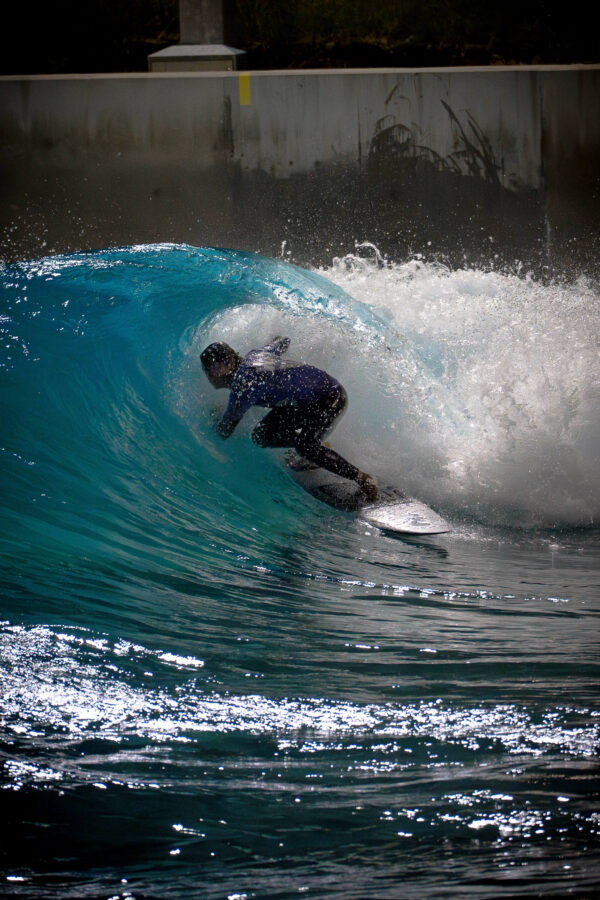 Surfer carving through a barrel wave at an indoor surf wave pool